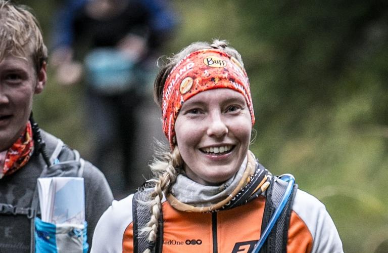 Vaarojen Maratonin juoksijat hymyilev&auml;t suorituksen aikana Kolin kansallispuiston mets&auml;ss&auml;, kasvoilla innostunut ja energinen ilme.